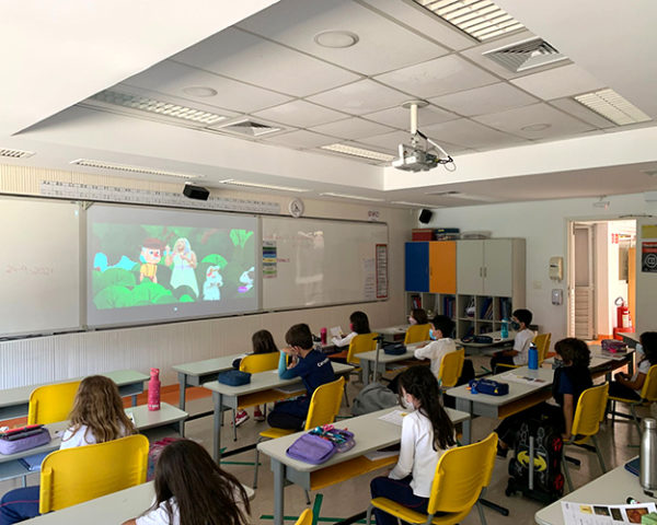 Na imagem os alunos 2º ano do Colégio estão na sala de aula assitindo a um vídeo na lousa digital da sala.